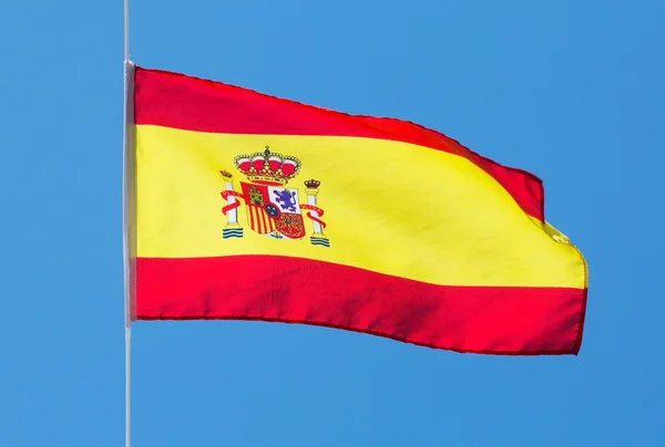 Spaanse vlag in de wind tegen de hemel — Stockfoto