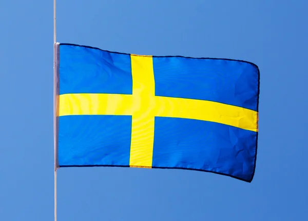 Schwedische Flagge im Wind gegen den blauen Himmel — Stockfoto