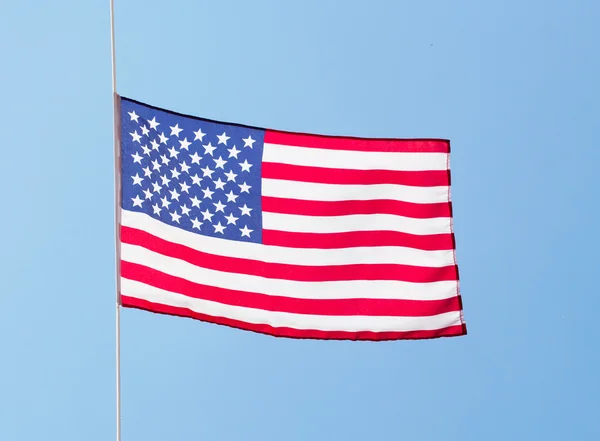 Az amerikai zászló a szélben a kék ég ellen — Stock Fotó