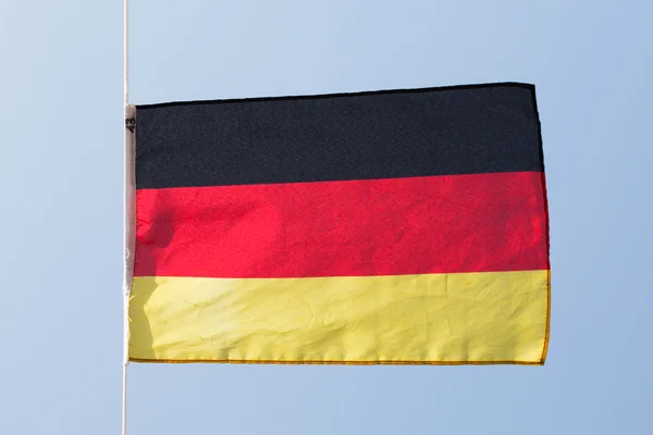 Niemiecka flaga na wietrze wobec niebo — Zdjęcie stockowe