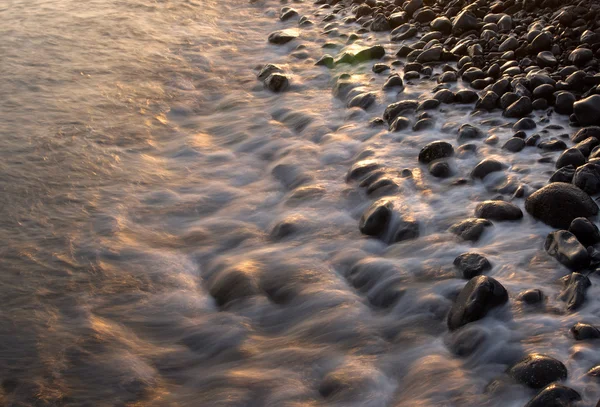 Havet kysten i lyset af den opgående sol - Stock-foto