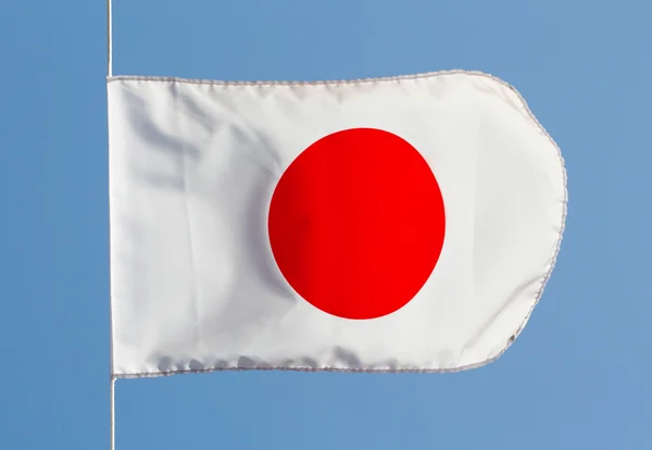 Японский флаг на ветру против неба — стоковое фото