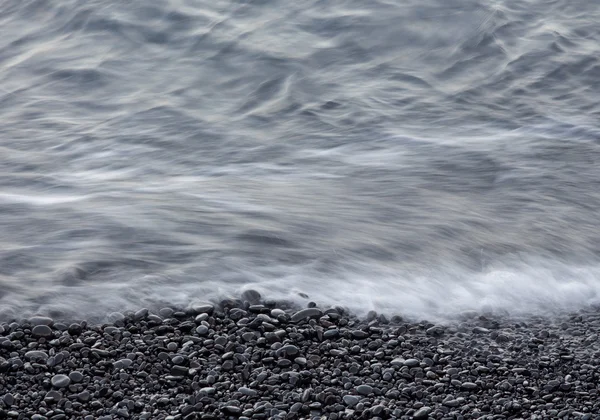 Kustnära stenar och och havsvågor — Stockfoto