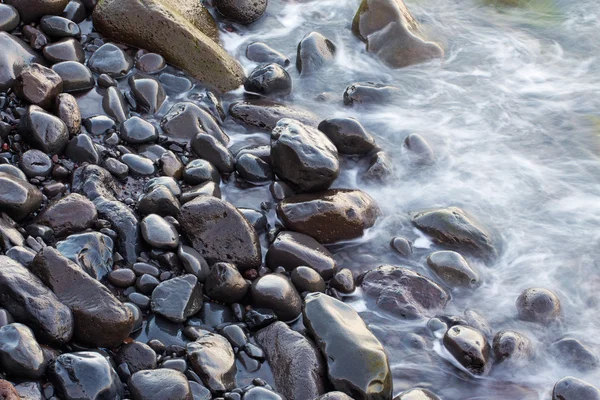 Kust natte rotsen en surf — Stockfoto