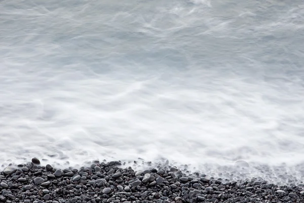 Kustnära stenar och havet surf — Stockfoto