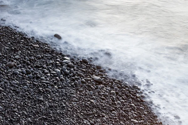 Kustnära stenar och havet surf — Stockfoto