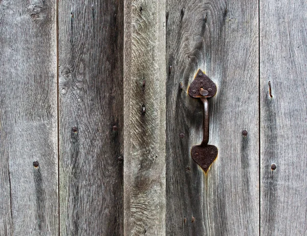 Rusty doorhandle of wooden door — Stock Photo, Image