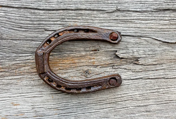 Vieux fer à cheval sur le fond en bois — Photo