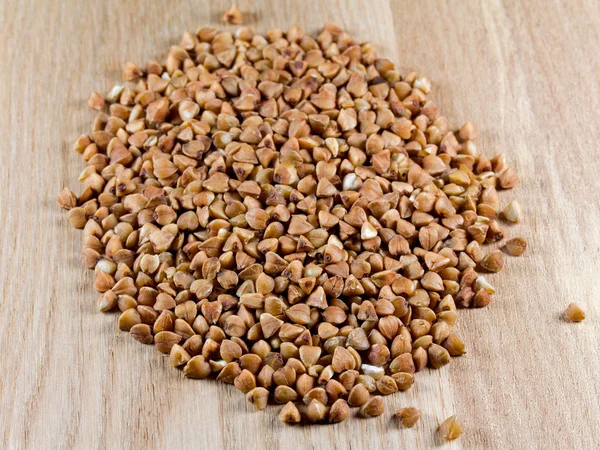 Buckwheat grains on wooden surface — Stock Photo, Image