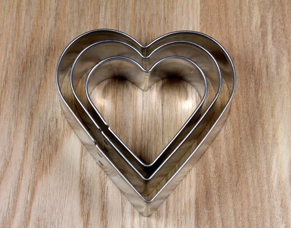 Heart shape cookie molds on wooden surface — Stock Photo, Image