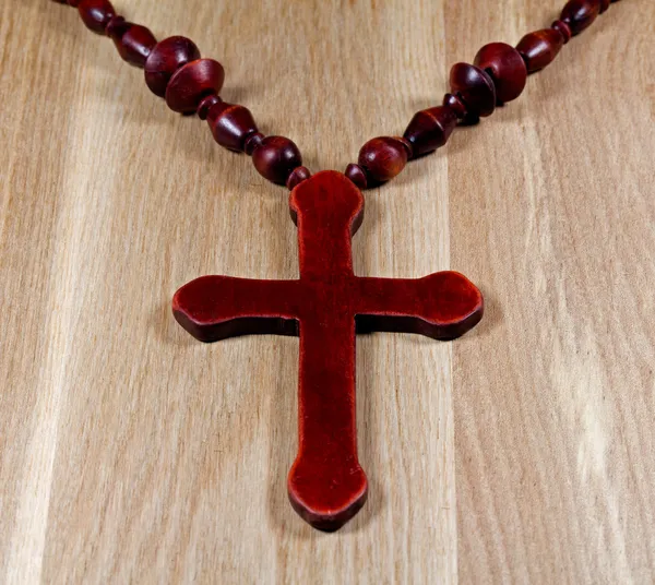 Christliches Kreuz auf hölzerner Oberfläche — Stockfoto