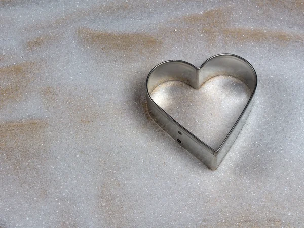 Molde de galletas en forma de corazón sobre madera y azúcar —  Fotos de Stock