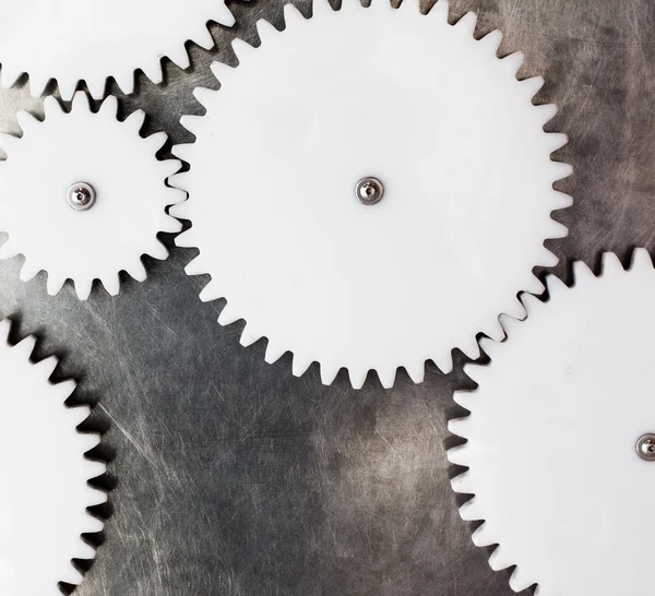 White plastic gears on metal surface — Stock Photo, Image