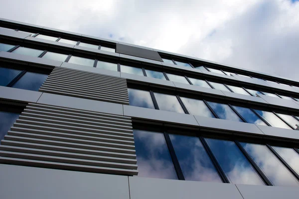 Arquitectura moderna de vidrio contra el cielo nublado — Foto de Stock