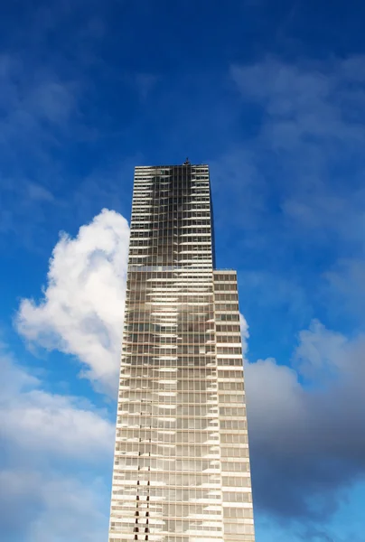 Skyscraper against a blue sky and clouds — Stock Photo, Image
