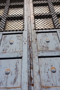 Güneş ışığı altında çubuklarla eski kapı