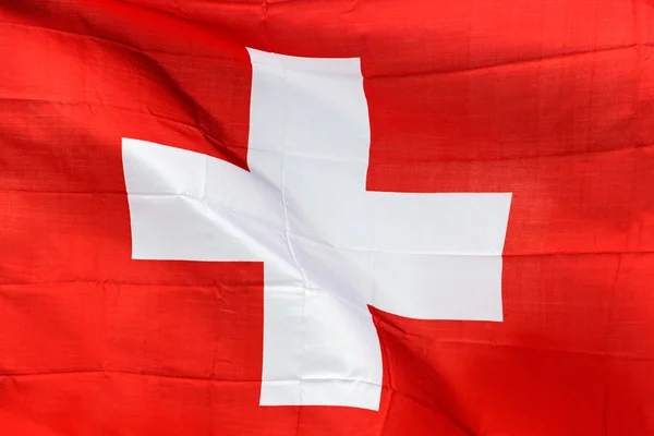 Swiss vlag in de wind in zonlicht — Stockfoto