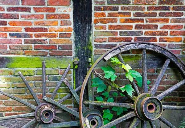 Stary zniszczony cartwheels w ścianie Izby rolnicze — Zdjęcie stockowe