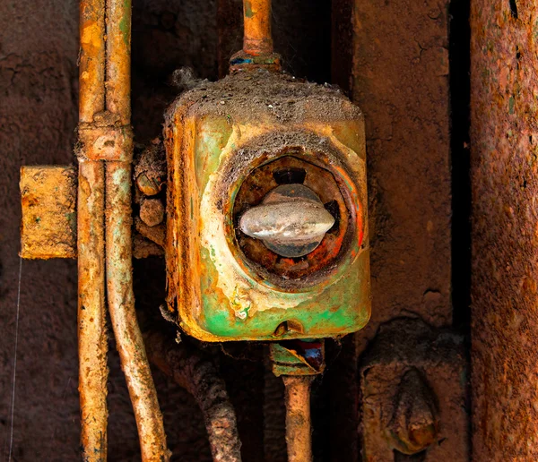 Oude elektrische schakelaar op een muur roestig ijzer — Stockfoto