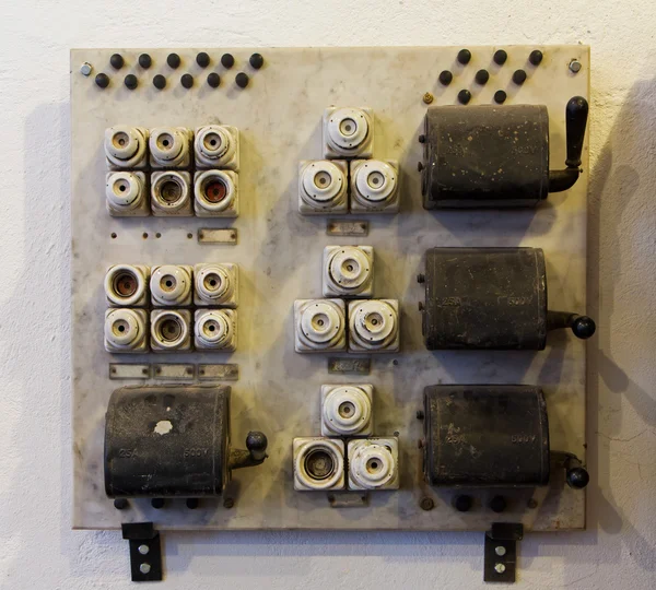 Ceramic fuses and knife switches on wall — Stock Photo, Image