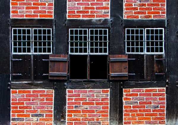 Ventanas con persianas en la pared de ladrillo de la casa de entramado — Foto de Stock