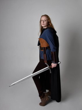Orta çağ Viking 'i giymiş, uzun boylu, kızıl saçlı bir kadının portresi..