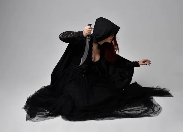 Полноразмерный Портрет Темноволосой Женщины Черном Костюме Ведьмы Сидящей Студийном Фоне — стоковое фото