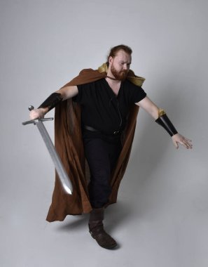  Ortaçağ Viking 'i giyen kızıl saçlı adamın portresi uzun kılıç tutan fantezi kostümüne ilham kaynağı oldu. Stüdyo geçmişine göre izole edilmiş