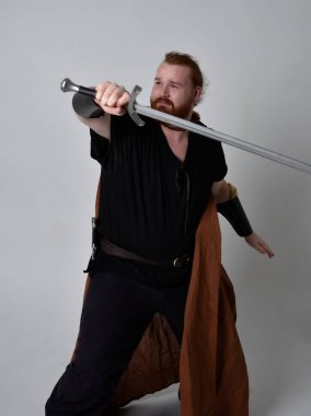  Ortaçağ Viking 'i giyen kızıl saçlı adamın portresi uzun kılıç tutan fantezi kostümüne ilham kaynağı oldu. Stüdyo geçmişine göre izole edilmiş