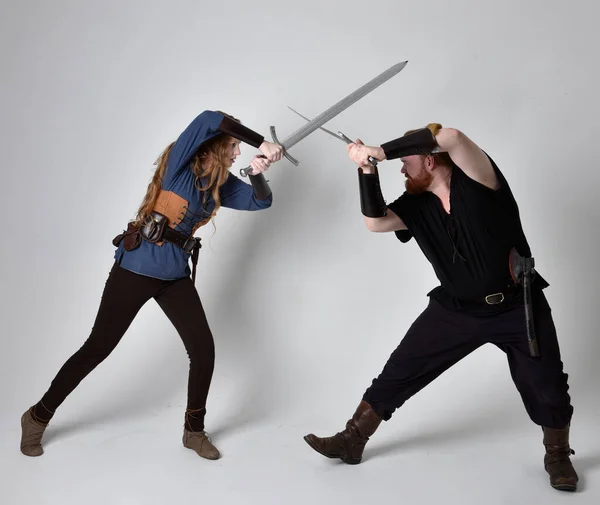 全长的红头发夫妇肖像 男人和女人穿着中世纪维京风格的奇幻服装 站在战斗的姿势 手持剑 隔离在白色的工作室背景下 — 图库照片
