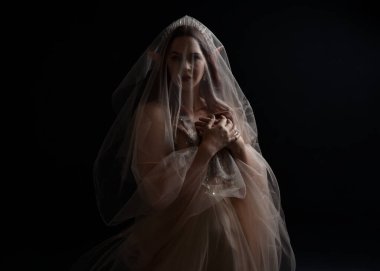 Peri tanrıçası kostümü gibi kremalı bir fantezi elbisesi giyen kızıl saçlı kızın tam boy portresi. Stüdyonun arka planında izole edilmiş zarif hareketli duruş..