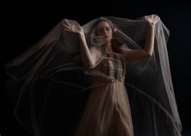 Peri tanrıçası kostümü gibi kremalı bir fantezi elbisesi giyen kızıl saçlı kızın tam boy portresi. Stüdyonun arka planında izole edilmiş zarif hareketli duruş..