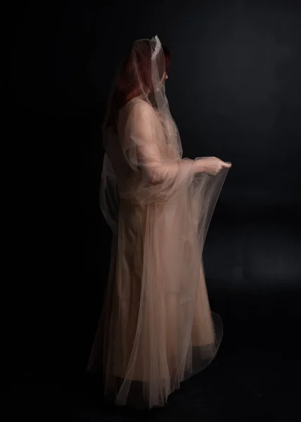 여자의 초상화 복장처럼 크림같은 가운을 스튜디오 배경에 고립된 몸짓으로 포즈를 — 스톡 사진