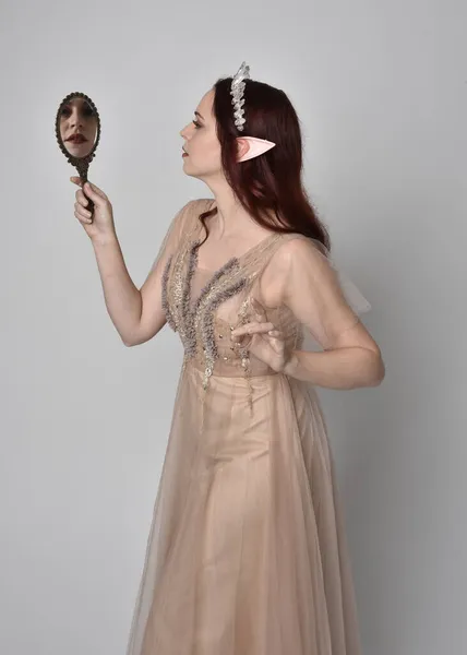 여자의 초상화에 크림같은 가운을 크리스탈 왕관을 복장처럼 황금빛 거울을 몸짓으로 — 스톡 사진