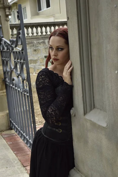 ゴージャスゴシックブラックレースのボールガウンを身に着けている赤い髪のきれいな女性モデルの肖像画 階段付きのおとぎ話の城の場所にポーズ — ストック写真