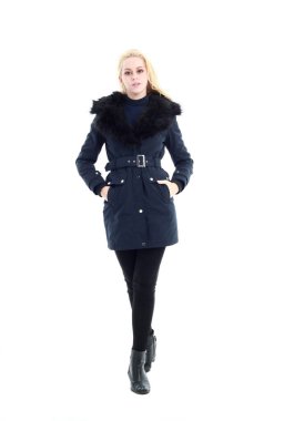 Uzun kışlık palto giyen sarışın kadının tam boy portresi. Ve günlük giysiler. Beyaz bir stüdyo arka planında izole edilmiş bir poz..