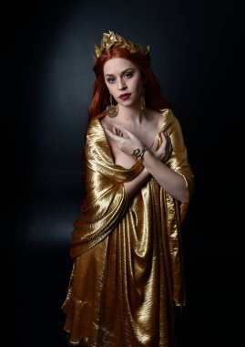  Yunan tanrıçası Toga elbisesi giymiş, stüdyo arka planında zarif hareketlerle poz veren güzel bir kadın modelin tam boy portresi..