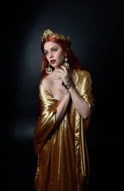  Yunan tanrıçası Toga elbisesi giymiş, stüdyo arka planında zarif hareketlerle poz veren güzel bir kadın modelin tam boy portresi..