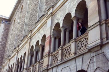 Kızıl saçlı güzel gotik bir elbise giyen, romantik kale taşı mimarisi geçmişi olan, uzun boylu bir kadın portresi..