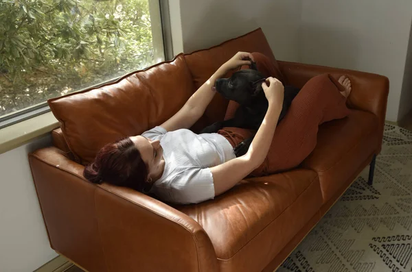 全长肖像画红头发的女孩穿着休闲装 在客厅的沙发上悠闲自在地躺着 — 图库照片