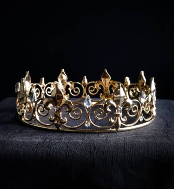 close up of a  beautiful real golden crown, isolated on dark black studio background.