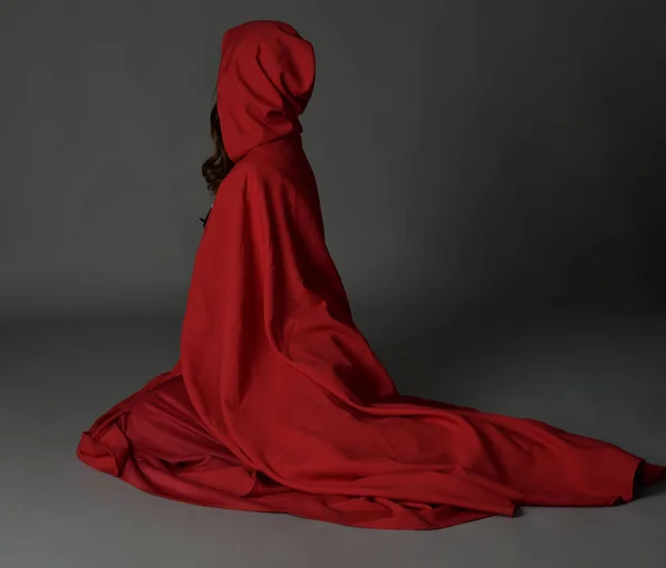 長いスカートと流れるフード付きクロークと赤い中世のファンタジーの衣装を身に着けている美しいブルネットの女性の完全な長さの肖像画 — ストック写真