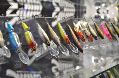 Many fishing lures on the glass stand clipart