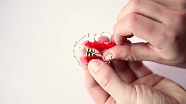 Inspeksjon av en barneplate med sikte på tanninnstilling, stramming av skruen på platen med en nøkkel. – stockvideo