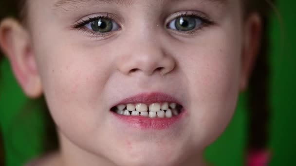 La niña muestra sus dientes de leche, dientes de leche blancos, higiene bucal, movimiento lento del niño. — Vídeos de Stock