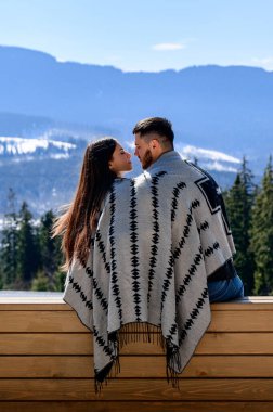 Karpatların arka planında, bir dağ köşkünün verandasında oturan sevgi dolu çift, aile tatili..
