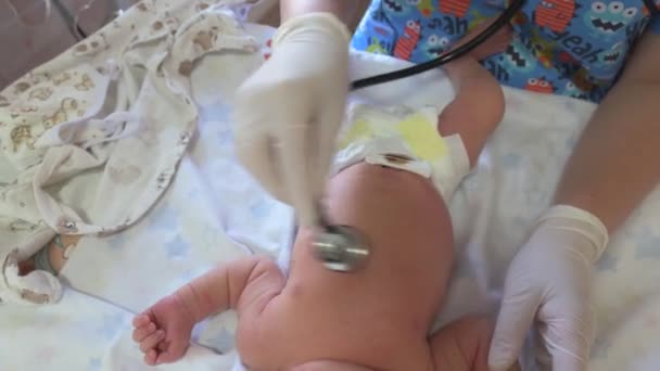 소아과 의사가 청진기를 사용하여 신생아의 말을 듣고 있다. — 비디오