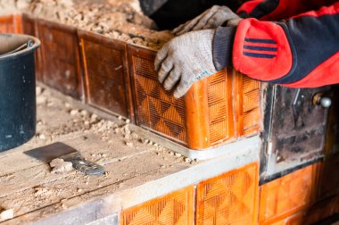 Adam eski bir tuğla ocağını yok ediyor, kurum içindeki siyah tuğlayı, eski mutfak yüzeyini söküyor. yeni