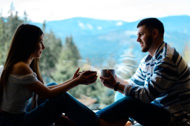 Genç bir çift, bir fincan kahve içerken, günlük meseleleri tartışırken, bir erkek ve bir kız, arka planda oturmuş, kahve içerken, Karpatlar 'da dinleniyorlardı..