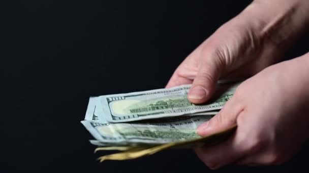 Contando notas de cem dólares, pessoas de negócios contam dinheiro, dinheiro em um fundo preto. — Vídeo de Stock